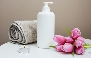 Massageöl mit Handtuch und Kerze für entspannende Wellness-Anwendung