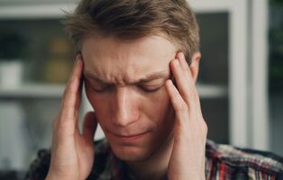 Mann mit Kopfschmerzen bei Migräne zur Darstellung von gezielter Therapie und Linderung